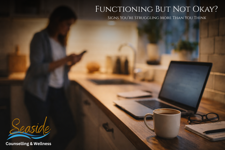 Person standing in a kitchen during a daily routine, appearing mentally distant while a laptop, phone, and coffee sit nearby